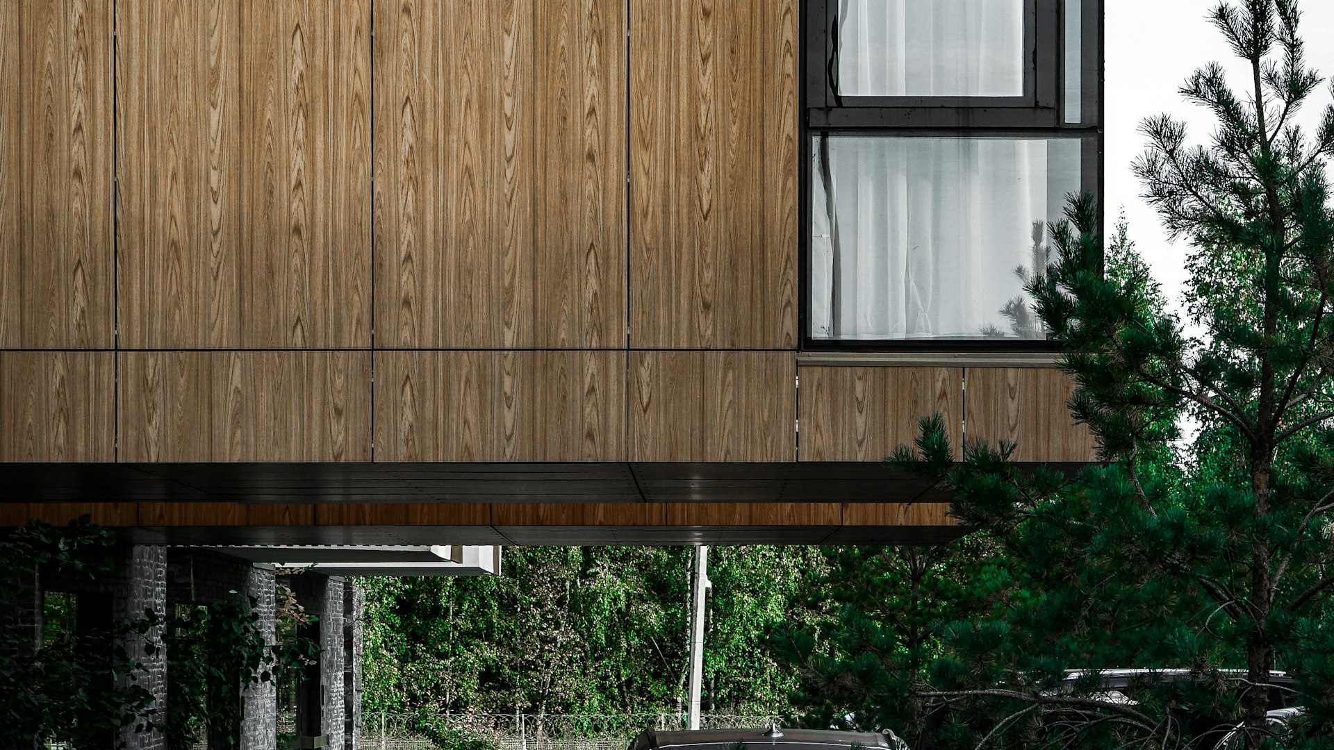 Vivienda de fachada de madera y grandes ventanales, ejemplo de construcción eficiente